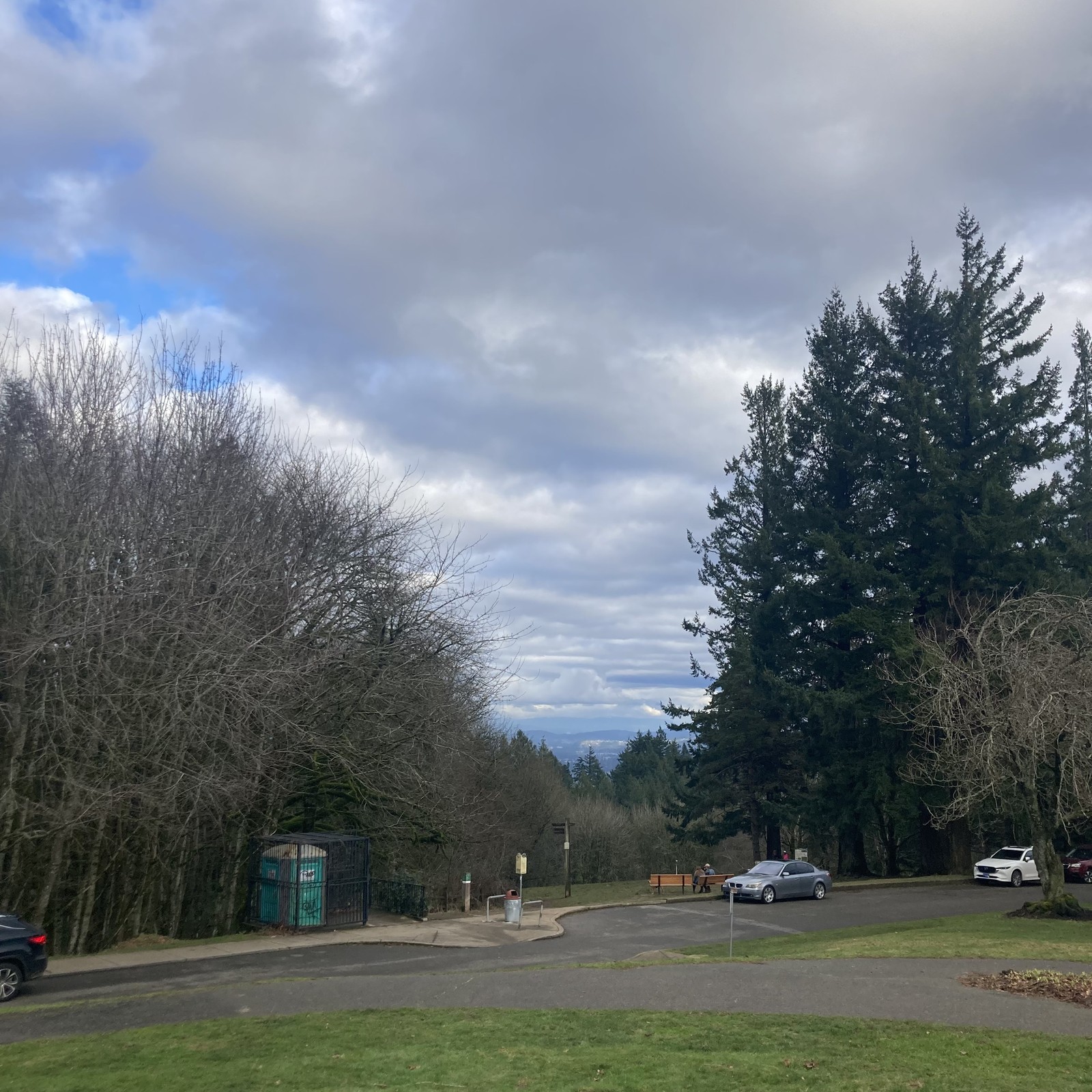 View from Council Crest Park toward Mt. Hood, which is hidden behind a broken, cloudy sky. The air is extremely clear and clean. A few patches of blue are visible behind the clouds.