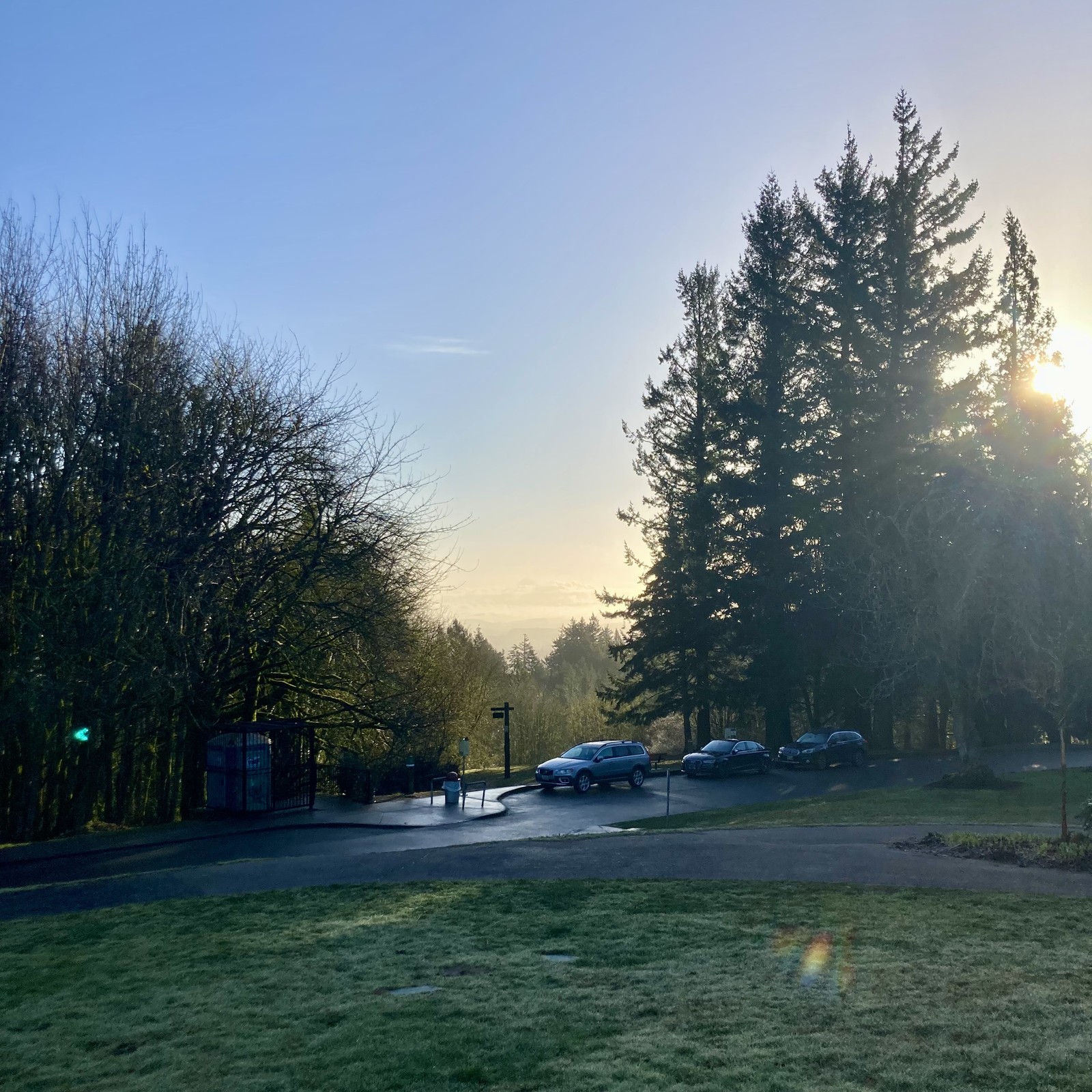 View from Council Crest Park toward Mt. Hood, under a clear sky. It is about an hour after sunrise and the eastern light shine through mists and low clouds between us and the mountain, the very tip of which is visible