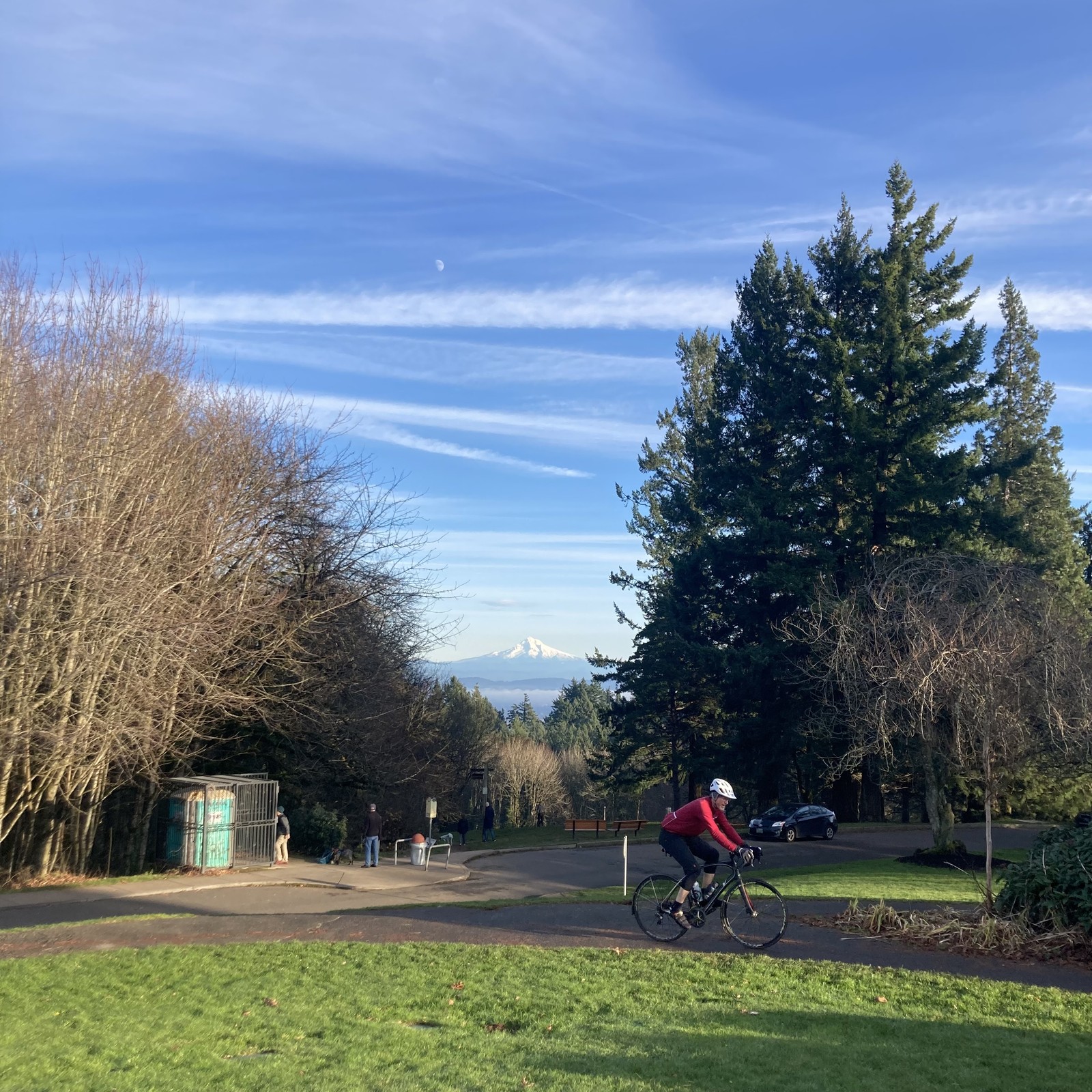 A cyclist in the near foreground rides past a view of Mt. Hood on the shortest day of the year