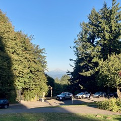 Barely any snow on the mountain in the waning days of summer. Long shadows. Clear sky.