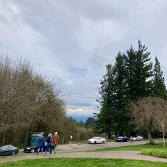 View from Council Crest Park toward Mt. Hood which is…let’s call it “not visible,” but geez it’s close. High deck of cirrostratus and small cumulus clouds hides the top of the mountain and the peaks of the foothills. But gaps of blue sky and sunshine. 65°F today and golly is the park busy! There was a wedding (behind me, I can hear it, but it’s not pictured) In the foreground three people walk down the hill toward a line of parked cars. Another cyclist is about 200' away riding up the road toward us at the top of the hill.