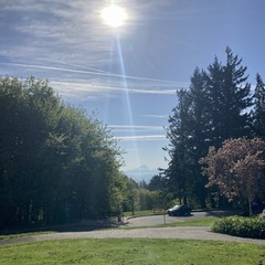 Mt. Hood, snow-capped under a bright blue May sky crossed with contrails and a few wispy cirrus clouds